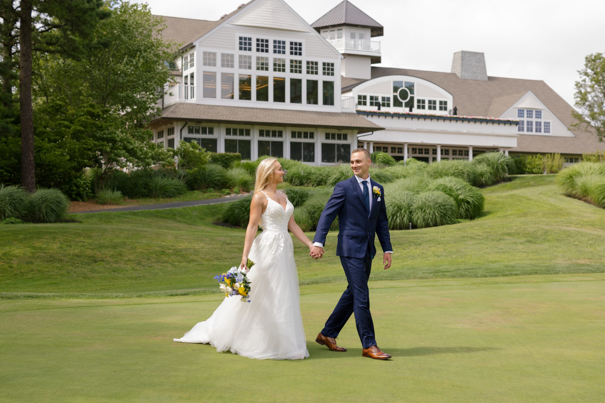 A newly married couple walking across the green at LBI National Golf Resort